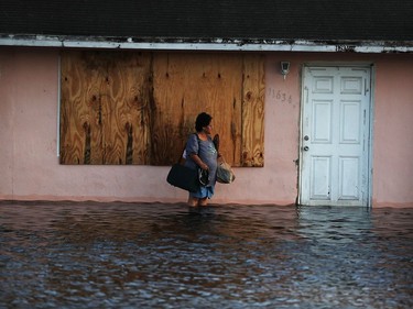 A woman leaves her flooded home the morning after Hurricane Irma swept through the area on Sept. 11, 2017, in Fort Myers, Florida.