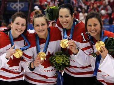 Catherine Ward #18, Marie-Philip Poulin #29, Caroline Ouellette #13 and Charline Labonté #32 of Canada celebrate with the gold medals following their team's 2-0 victory during the ice hockey women's gold medal game between Canada and USA on day 14 of the Vancouver 2010 Winter Olympics at Canada Hockey Place on February 25, 2010 in Vancouver, Canada.