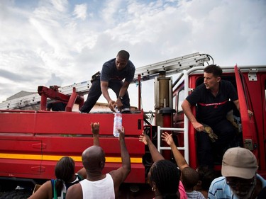 French firemen hand out water to inhabitants of the Sandy Ground area of Marigot, Sept. 10, 2017 on Saint-Martin island, devastated by Hurricane Irma. (Martin Bureau, AFP/Getty Images)