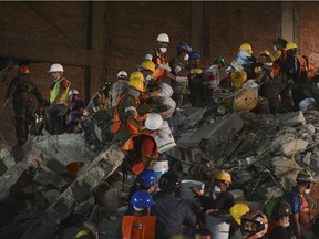 Soldiers and volunteers remove rubble from a collapsed building in Colonia Condesa, an area of Mexico City strongly affected by the September 19 quake, early on September 22, 2017, three days after a strong quake hit central Mexico.
