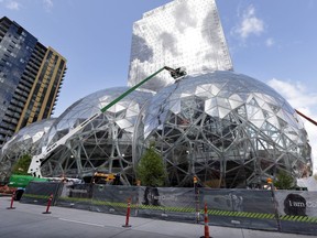 In this April 27, 2017 file photo, construction continues on three large, glass-covered domes as part of an expansion of the Amazon.com campus in downtown Seattle. Amazon said Thursday, Sept. 7, that it will spend more than $5 billion to build another headquarters in North America to house as many as 50,000 employees. It plans to stay in its sprawling Seattle headquarters and the new space will be "a full equal" of its current home, said founder and CEO Jeff Bezos.