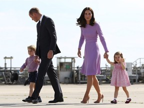 In this Friday, July 21, 2017 file photo Britain's Prince William, second left, and his wife Kate, the Duchess of Cambridge, second right, and their children, Prince George, left, and Princess Charlotte, right are on their way to board a plane in Hamburg, Germany. Kensington Palace says Prince William and his wife, the Duchess of Cambridge, are expecting their third child.