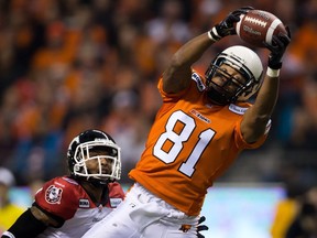 B.C. Lions' Geroy Simon catches a pass for a first down as Calgary Stampeders' Quincy Butler looks on during the first half of the CFL Western Final football game in Vancouver, B.C., on Sunday November 18, 2012.