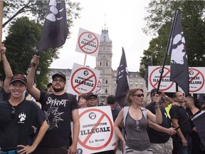 Members of right-wing group La Meute demonstrate in silence in front of the legislature, Sunday, Aug. 20, 2017 in Quebec City.