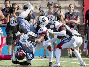 Montreal Alouettes' Tyrell Sutton is upended by Ottawa Redblacks defenders during first half CFL football action against the Ottawa Redblacks in Montreal, Sunday, Sept. 17, 2017.