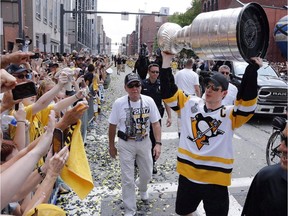 Pittsburgh Penguins' Sidney Crosby hoists the Stanley Cup for fans during the team's Stanley Cup NHL hockey victory parade on Wednesday, June 14, 2017, in Pittsburgh. The Stanley Cup champion Pittsburgh Penguins say they've accepted an invitation from Donald Trump to visit the White House, while players, coaches and owners in the NFL and NBA have been involved in an escalating war of words with the U.S. president.