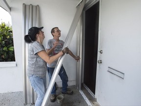 Nancy Teske Wissler helps her husband Dean board up the house in preparation for the arrival of hurricane Irma Friday, September 8, 2017 in Hollywood, Fla. THE CANADIAN PRESS/Paul Chiasson