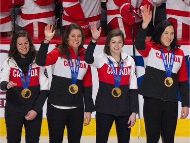 Canada Women's Olympic Hockey Team members, from left, Mélodie Daoust, Charline Labonté, Genevieve Lacasse and Caroline Ouellette wave to the crowd with their Sochi Olympic gold medals around their necks prior to a game between the Montreal Canadiens and the Detroit Red Wings at the Bell Centre on Feb. 26, 2014.