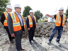 Lavacon's Guy Pascal (right), gives Montreal Mayor Denis Coderre, provincial finance minister Carlos Leitao (left) and Pierrefonds-Roxboro borough mayor Jim Beis a tour of the new Pierrefonds Library construction site on Aug. 25.