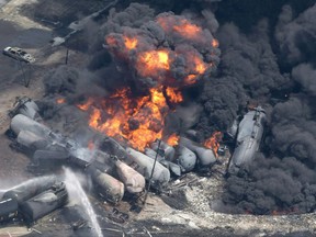 Smoke rises from railway cars that were carrying crude oil after derailing in downtown Lac-Mégantic, Que., Saturday, July 6, 2013.