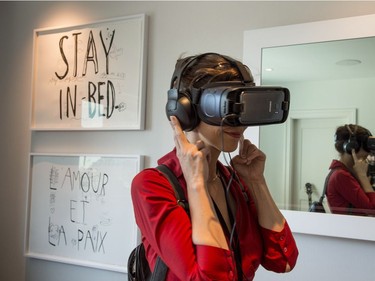 A woman dons a virtual-reality headset in the Queen E's revamped Suite 1742, suite made famous by John Lennon and Yoko Ono during their 1969 bed-in for peace, Thursday, September 21, 2017 in Montreal. THE CANADIAN PRESS/Paul Chiasson