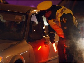 An Ottawa police officer interviews a driver during a December 2009 RIDE check. Rules for when people can be breathalyzed are being eased by the federal Liberals, writes Tyler Dawson. Jean Levac, Ottawa Citizen