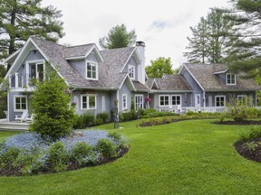 The wood siding of the residence is stained a pale, greyish-blue to imitate the bleached look of seaside cottages found on Nantucket Island.