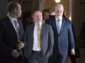 Quebec Premier Philippe Couillard, right, accompanied by his chief of staff Jean-Louis Dufresne, centre, and press attache Harold Fortin in February 2017.