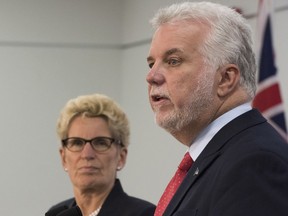 Quebec Premier Philippe Couillard, right, speaks at a news conference as Ontario Premier Kathleen Wynne looks on, at the end of a joint cabinet meeting between Quebec and Ontario, Friday, September 22, 2017 in Quebec City.