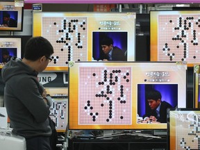 South Korean professional Go player Lee Sedol is seen on the TV screens during the Google DeepMind Challenge Match against Google's artificial intelligence program, AlphaGo, in Seoul in 2016.