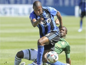 Montreal Impact captain Patrice Bernier is tackley Portland Timbers Diego Chara during first half MLS action in Montreal on Saturday May 20, 2017.