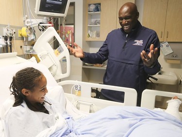 Montreal Alouettes coach and GM Kavis Reed shares a laugh with twelve year-old Naomi Cobbler-Roberts, during the team visit at the Montreal Children's hospital on Monday October 2, 2017.
