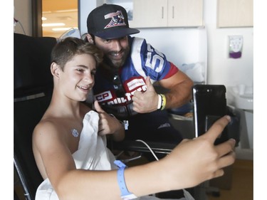 Emeric Legendre Perron gets a selfie with Alouettes player Nicolas Boulay as the team was visiting the Montreal Children's hospital on Monday October 2, 2017. (
