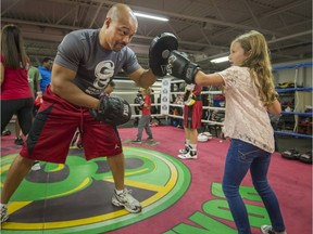 Lily Friedman, 7, of Pierrefonds does a round of exercises with Otis Grant during a Boxathon fundraiser in Dorval on Sunday. Money raised during the event will go to help two foundations, the Otis Grant and Friends Foundation and CARE Jeunesse.