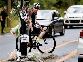 A cyclist stops to look at a memorial on Camillien-Houde Way for 18-year-old Clément Ouimet in Montreal on Friday October 6, 2017. Ouimet was killed while cycling on Mount Royal.