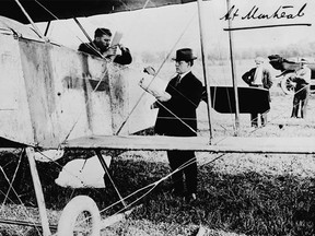 B.A. Macnab, editor of the Montreal Daily Mail, handing newspapers to pilot William C. (Billy) Robinson in his Lillie biplane at the start of his Montreal-Ottawa flight, Oct. 8, 1913.