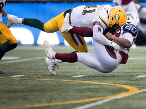 Montreal Alouettes running back Tyrell Sutton is tackled by Edmonton Eskimos defensive end Odell Willis in Montreal on Monday, Oct. 9, 2017.