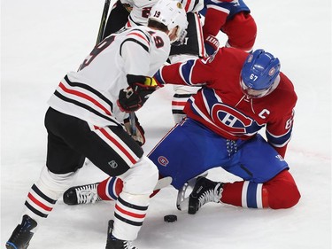 Montreal Canadiens' Max Pacioretty (67) tries to get away from the puck as he falls on it with Chicago Blackhawks' Jonathan Toews (19) coming in close, during first period NHL action in Montreal on Tuesday October 10, 2017.