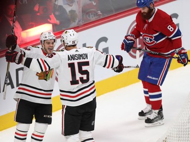 Montreal Canadiens' Jordie Benn (8) puts his head down as he stakes past Chicago Blackhawks' Alex DeBrincat (12) celebrating the goal of Artem Anisimov (15), during second period NHL action in Montreal on Tuesday October 10, 2017.