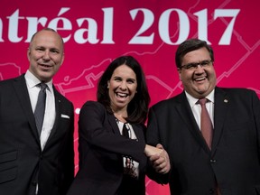 Michel Leblanc, left, president and CEO of the Board of Trade of Metropolitan Montreal, Denis Coderre and Valérie Plante pose for a pictures on the stage as they prepare to take part in the French-language debate during the municipal elections in Montreal on Thursday Oct. 19, 2017.