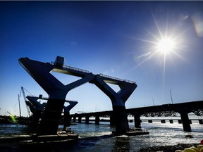 Piers for the new Champlain Bridge are silhouetted next to the old bridge in Montreal on Friday, Oct. 20, 2017.