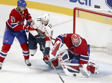 Montreal Canadiens Carey Price makes a save as teammate Max Pacioretty checks Florida Panthers Jonathan Huberdeau during first period of National Hockey League game in Montreal Tuesday October 24, 2017.