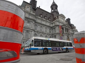 STM bus is framed by construction cones and Montreal city hall.