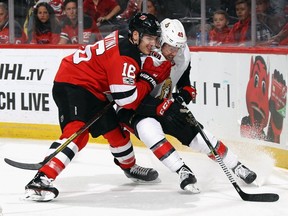 Steven Santini of the New Jersey Devils rides Chris DiDomenico of the Ottawa Senators into the boards during the third period at the Prudential Center on October 27, 2017 in Newark, New Jersey. The Devils defeated the Senators 5-4 in the shoot out.