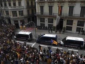 Protesters wave a Catalan pro-independence 'Estelada' flag as they gather outside the Spanish police headquarters in Barcelona as part of a general strike in Catalonia called by Catalan unions on October 3, 2017. Large numbers of Catalans are expected to observe a general strike today to condemn police violence at a banned weekend referendum on independence, as Madrid comes under growing international pressure to resolve its worst political crisis in decades.