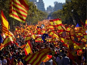 Protesters wave Spanish and Catalan Senyera flags during a pro-unity demonstration in Barcelona on Oct. 29, 2017. Pro-unity protesters were to gather in Catalonia's capital Barcelona, two days after lawmakers voted to split the wealthy region from Spain, plunging the country into an unprecedented political crisis.