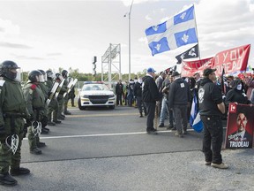 The Sûreté du Québec keep members of Storm Alliance away from opposing protesters during a demonstration in Lacolle on Sept. 30.
