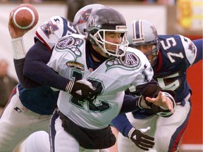 Montreal Alouettes'  Tom Hipsz, right, and Swift Burch sack Toronto Argonauts' Kerwin Bell during Eastern semifinal in Montreal in 1998.