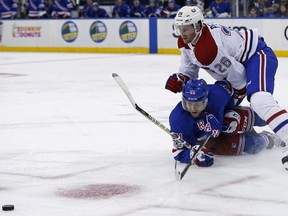 New York Rangers' David Desharnais (51) falls to the ice fighting for the puck with Montreal Canadiens' Jeff Petry (26) in the second period of an NHL hockey game Sunday, Oct. 8, 2017, in New York.