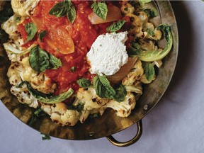 Roasted cauliflower is topped with tomato sauce and accented with ricotta cheese and basil.