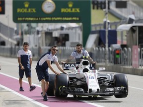 The crew for Williams driver Lance Stroll, of Canada, push his car down pit lane to the inspection garage, before the Formula One U.S. Grand Prix auto race at the Circuit of the Americas, Thursday, Oct. 19, 2017, in Austin, Texas.