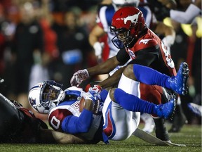 Alouettes running back Stefan Logan is tackled by a Calgary Stampeder during second-half CFL action in Calgary on Friday, Sept. 29, 2017.