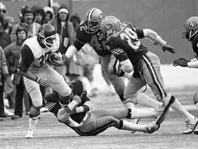 Edmonton Eskimos' Dan Kepley (42) and Joe Hollimon (29) chase Montreal Alouettes' John O'Leary as Eskimos' Herb Dobbins holds on during Grey Cup action in Montreal on Nov. 27, 1977.