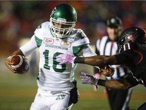 Saskatchewan Roughriders quarterback Brandon Bridge, left, runs from Calgary Stampeders' Josh Bell during second half CFL football action in Calgary, Friday, Oct. 20, 2017.