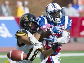 Alouettes' Michael Carter, right, is tackled by Hamilton Tiger Cats' Junior Collins in Montreal on Sunday, Oct. 22, 2017.