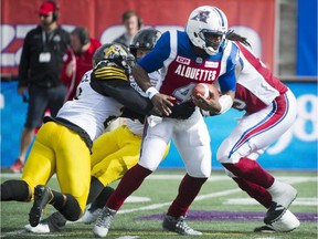 Alouettes quarterback Darian Durant is sacked by Hamilton Tiger-Cats' Simoni Lawrence (21) during first half action at Molson Stadium on Sunday.