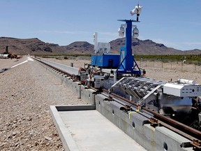 A recovery vehicle and a test sled sit on rails after the first test of the propulsion system at the Hyperloop One Test and Safety site on May 11, 2016 in Las Vegas, Nevada. A Montreal-Toronto-Ottawa loop is under study.