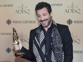 Adam Cohen, son of Leonard Cohen, holds up an honorary award for his father at the gala de l'ADISQ awards ceremony in Montreal on Sunday, Oct. 29, 2017.