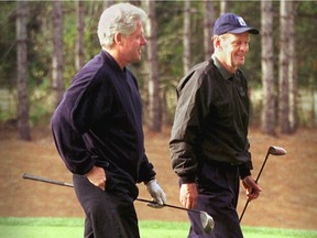 U.S. President Bill Clinton walks off the first tee with Prime Minister Jean Chrétien at the start of their round of golf at Le Diable golf course in Mont Tremblant on Oct. 8, 1999. The men will have a reunion Wednesday, Oct. 4, 2017 in Montreal at an event organized by the Canadian American Business Council to celebrate 150 years of Canada-U.S. collaboration.