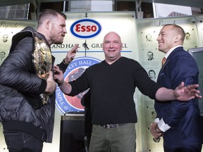 Canadian fighter Georges St-Pierre (right) and British fighter Michael Bisping 'square off' as UFC President Dana White stands between them as they promote UFC 217 during a news conference in Toronto on Friday October 13, 2017. THE CANADIAN PRESS/Chris Young
